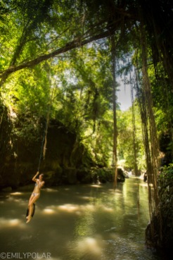 Women swimming with in lush forest river in Bali, Indonesia.