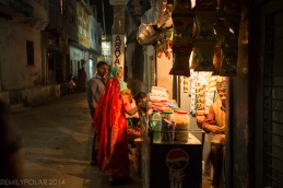 Women buying from local street shop in the night streets of Udaipur.
